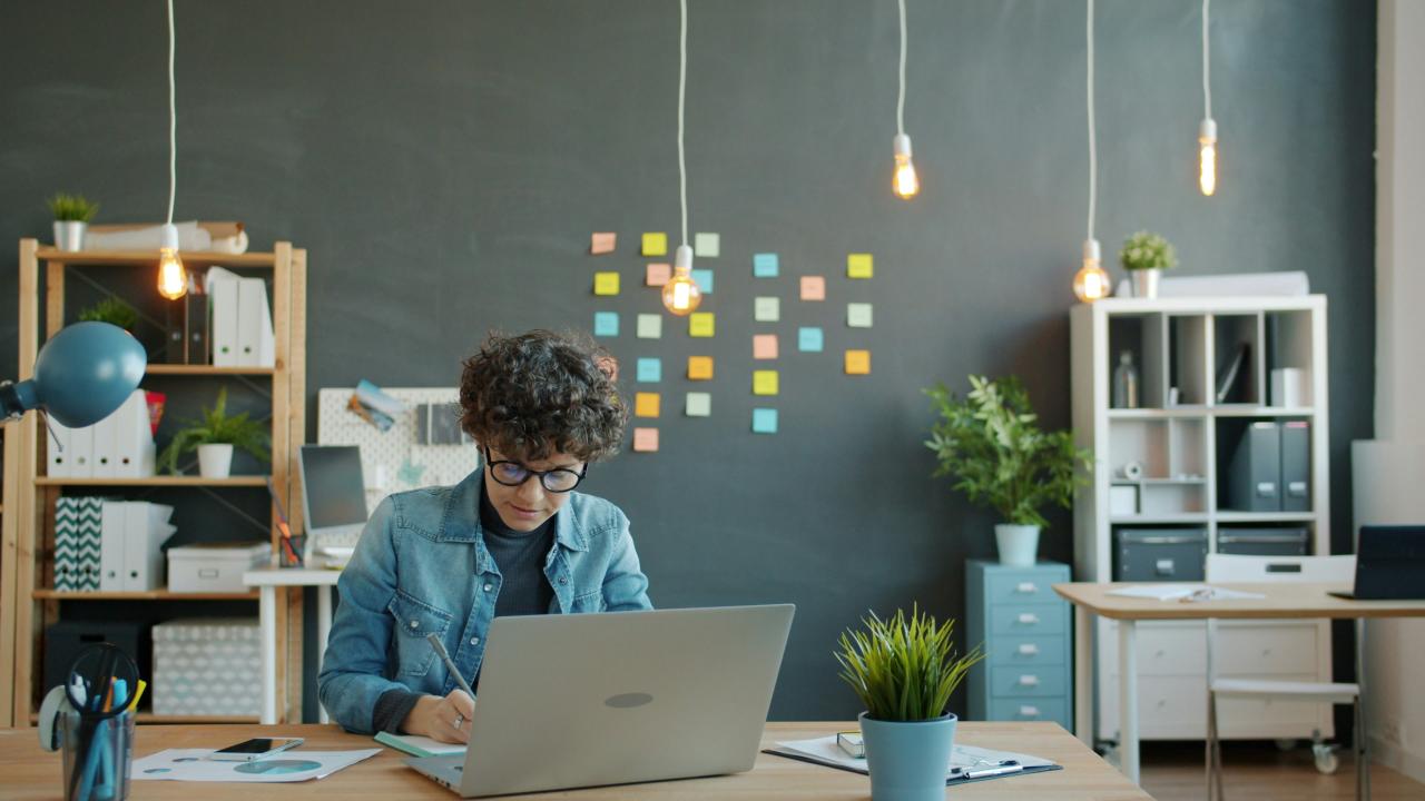 Orang muda yang bekerja di laptop di kantor modern.